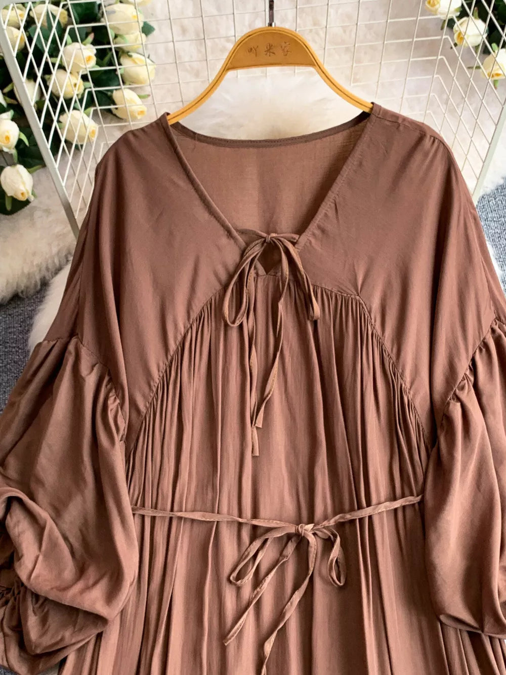 Brown bohemian maxi dress with balloon sleeves, V-neck tie, and cinched waist.