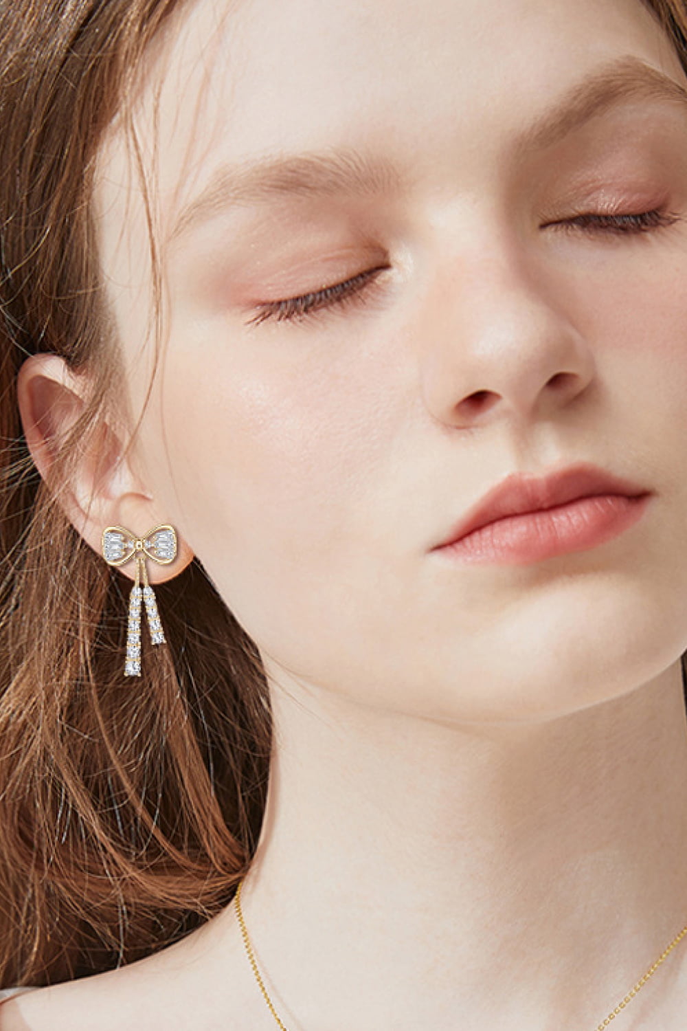 Gold bow drop earrings with baguette crystal tassels