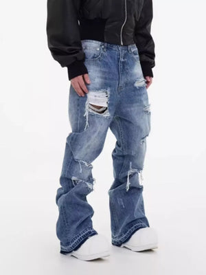 Men's distressed baggy fit blue denim jeans with rips and fading.