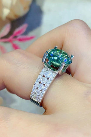 Verdant moissanite pavé band ring with a large green center stone and diamond-encrusted band.