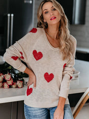 Eggshell knit sweater with red heart motif, scoop neck, raglan sleeves, and ribbed cuffs.