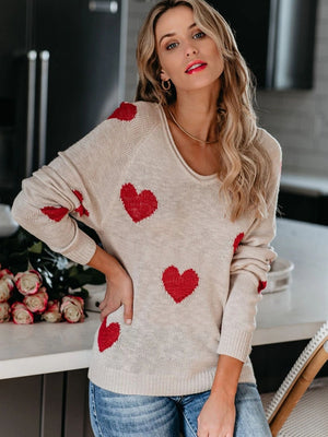 Eggshell knit sweater with red heart motif, scoop neck, raglan sleeves, and ribbed cuffs.