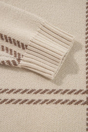 Tan knit crewneck pullover with brown gridline pattern and ribbed cuffs.