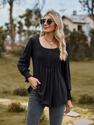 Black peplum blouse with gathered yoke and smocked cuffs
