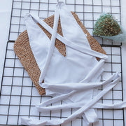 White wrap-around halterneck plunge swimsuit with crisscross straps and tie closure.