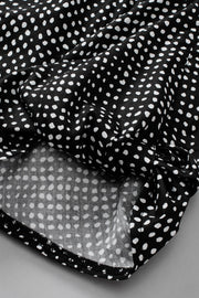 Black dotted puff sleeve blouse with tie detail.