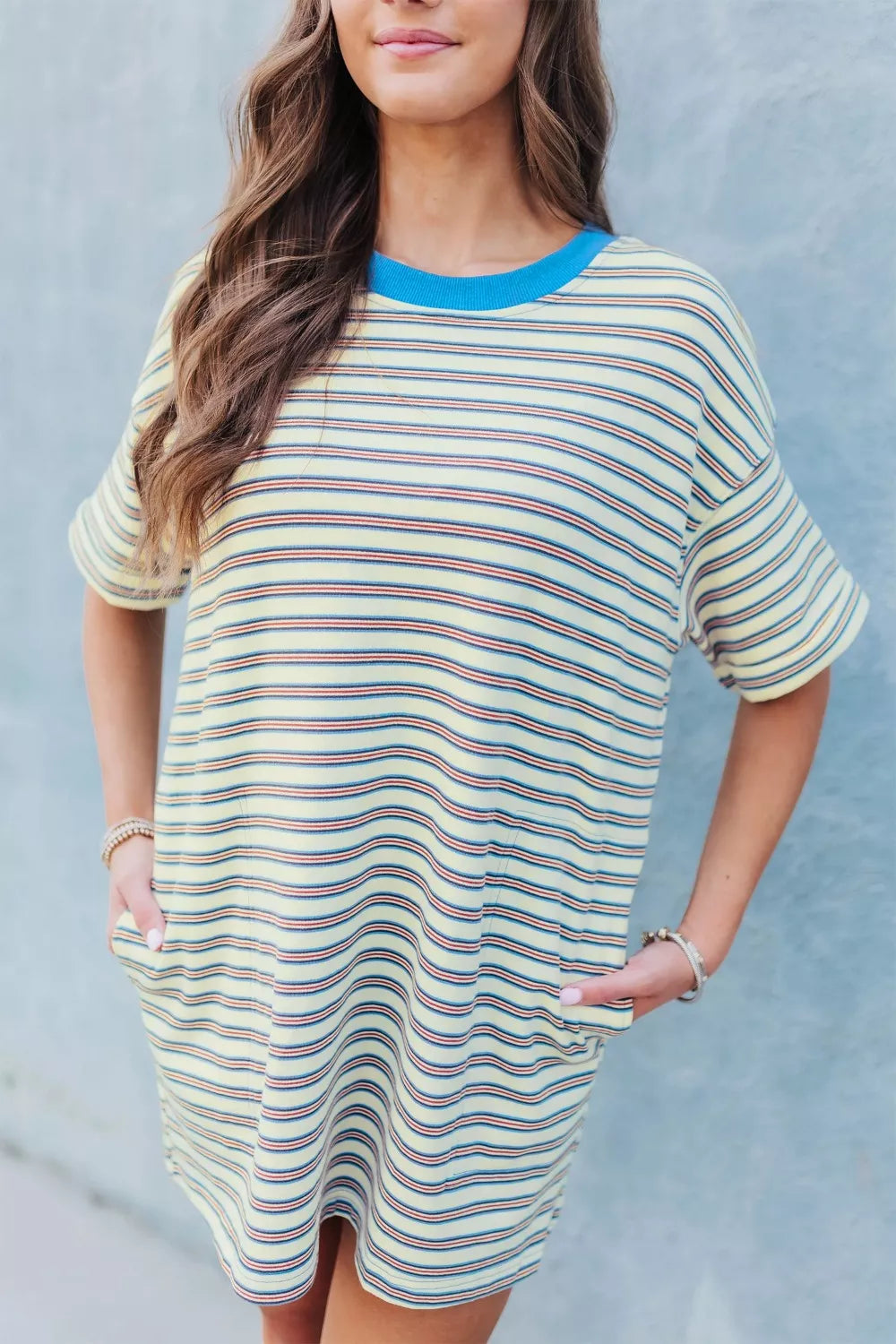 Casual striped mini dress with pockets in yellow, red, and blue stripes, crew neck, short sleeves.