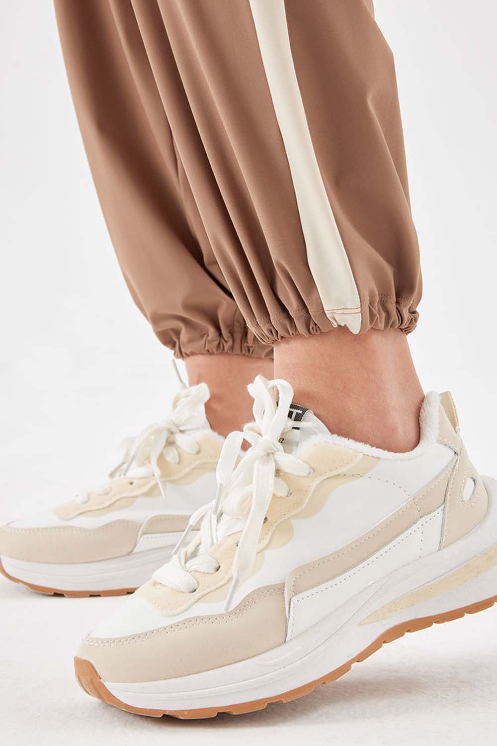 Camel relaxed trousers with cream side stripe detail and elasticated cuffs.
