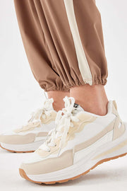Camel relaxed trousers with cream side stripe detail and elasticated cuffs.