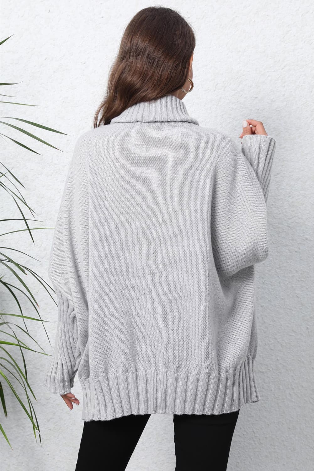Light gray ribbed knit turtleneck sweater with batwing sleeves and ribbed cuffs and hem.