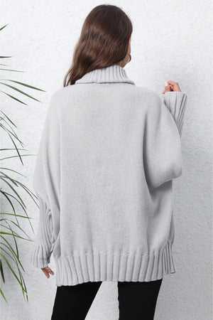 Light gray ribbed knit turtleneck sweater with batwing sleeves and ribbed cuffs and hem.