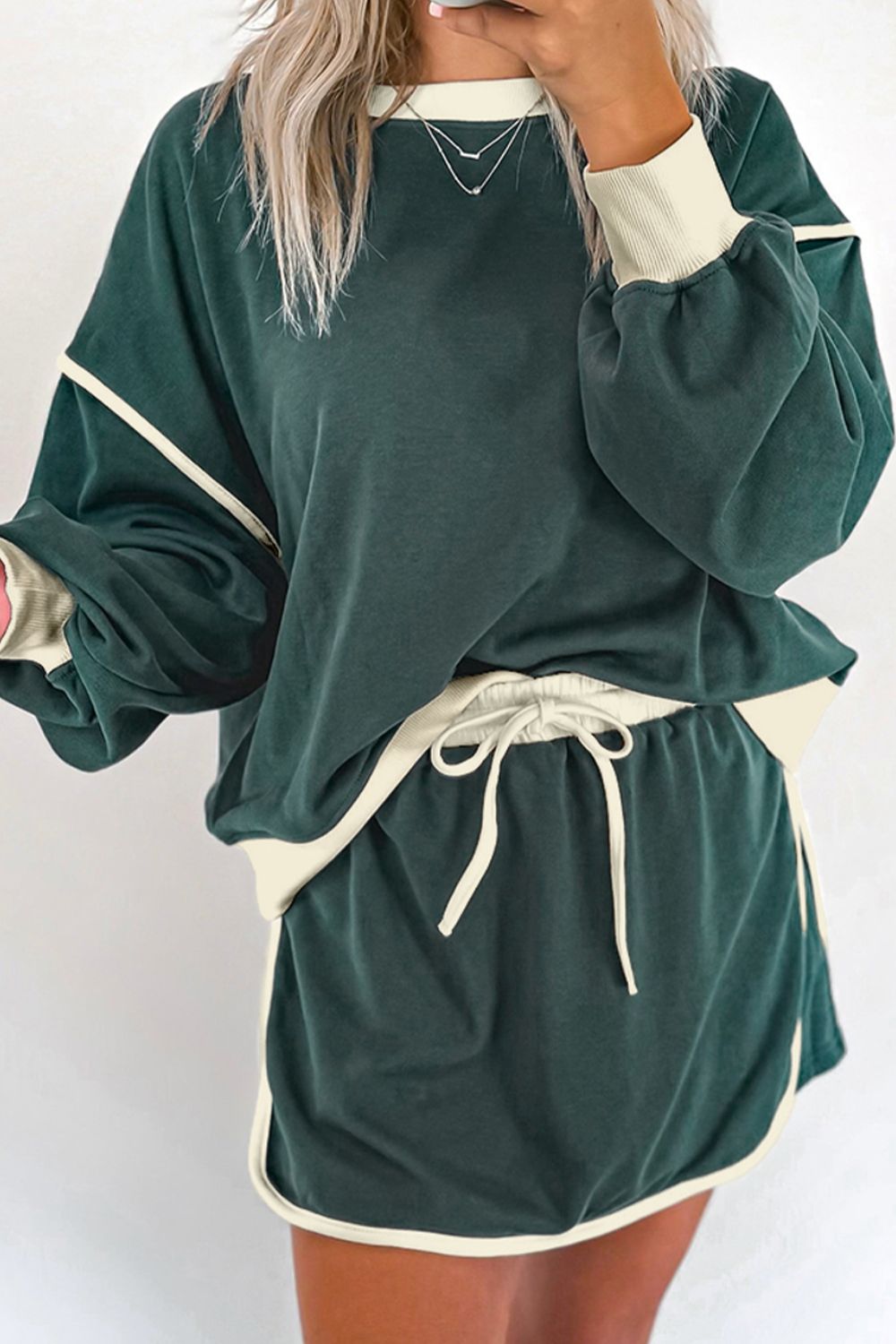 Dark green sweatshirt and skort set with cream contrast trim and drawstring waist.