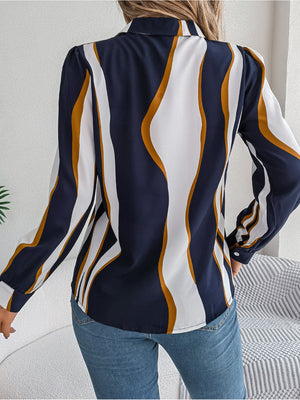Dark blue collared blouse with wavy white and gold stripes, long sleeves.