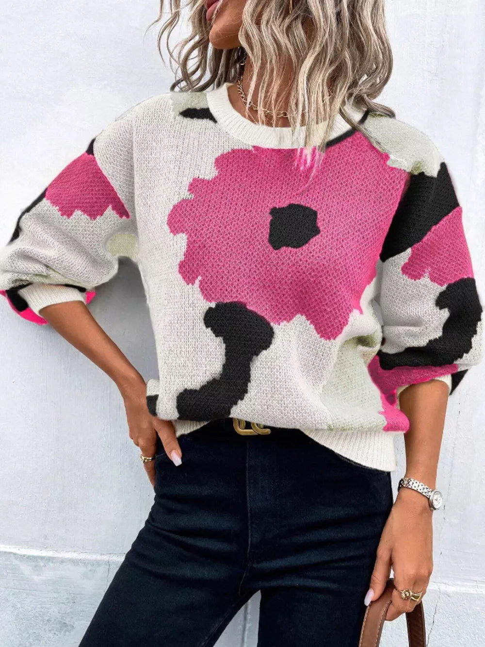 Abstract floral knit sweater with round neck in pink, black, and white.