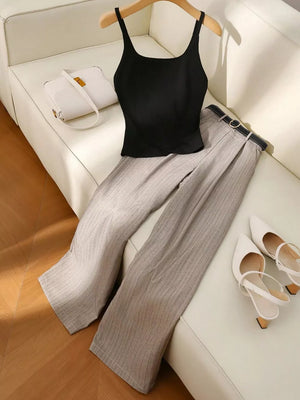 Sleeveless black tank top with pinstripe wide-leg pants and a belt.
