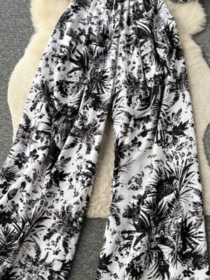 Tropical print smocked wide-leg romper in black and white.