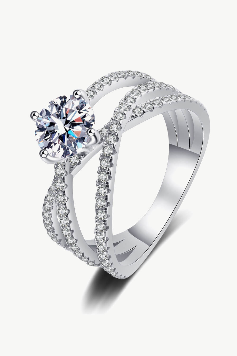 Silver pavé-set crossover engagement ring with a round-cut center stone.