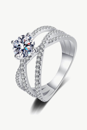 Silver pavé-set crossover engagement ring with a round-cut center stone.