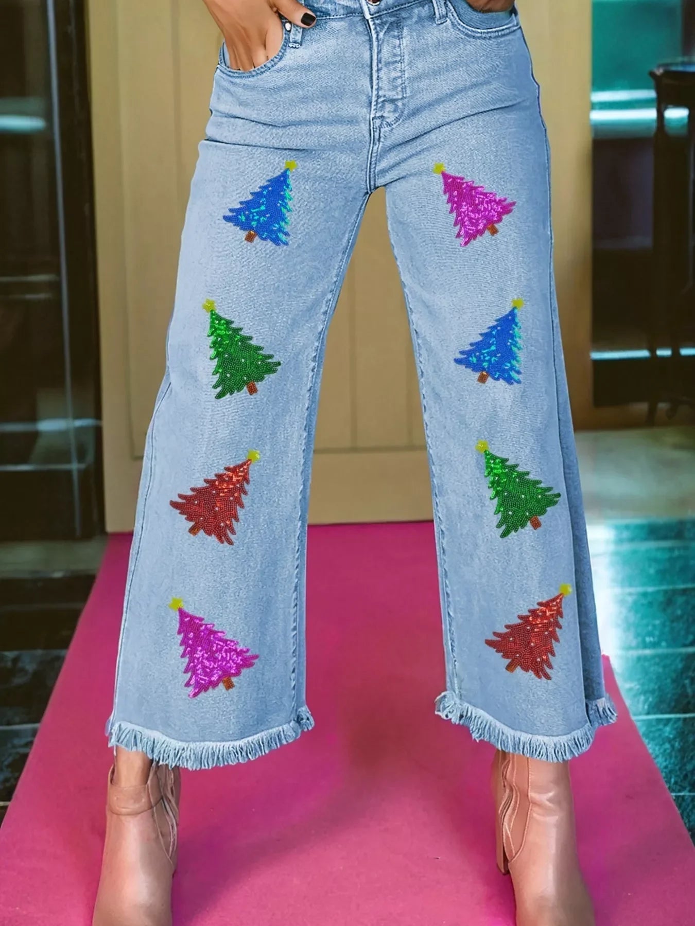 Light wash denim cropped wide-leg jeans with sequin Christmas tree appliques and frayed hem.