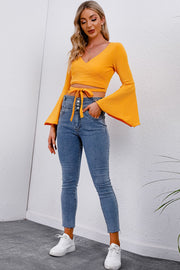 Pumpkin wrap tie crop blouse with bell sleeves and V-neck.