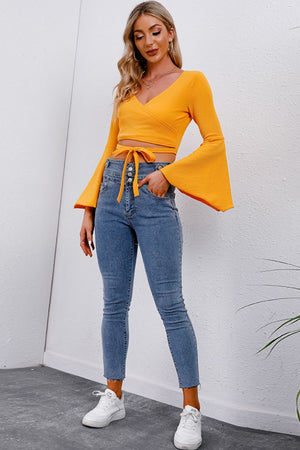Pumpkin wrap tie crop blouse with bell sleeves and V-neck.