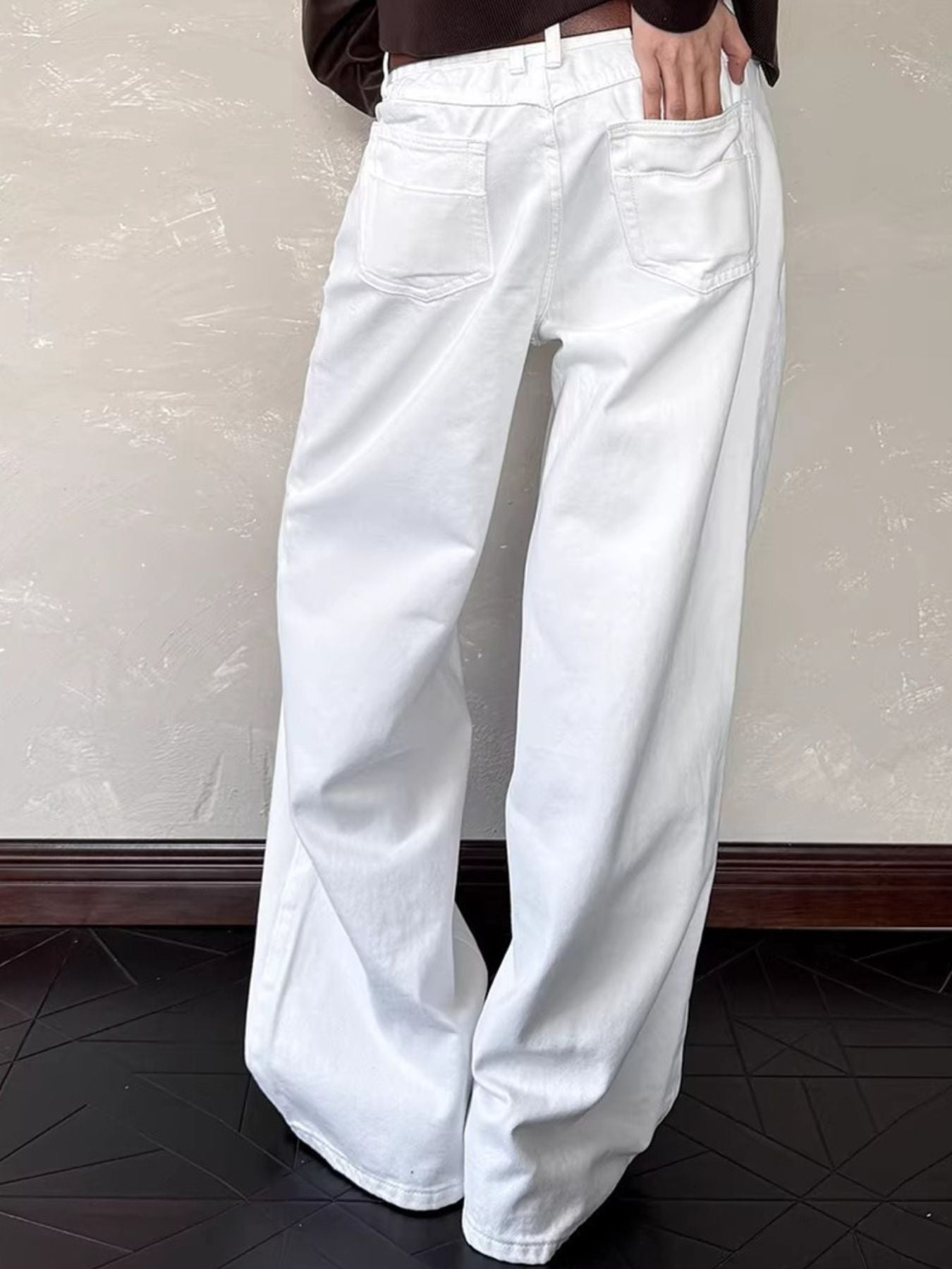 White cotton belted wide leg jeans with back pockets visible.