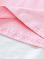 Pink cotton polo shirt hem detail with strawberry embroidery visible.