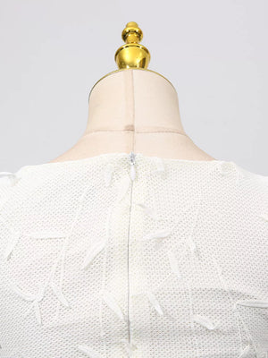 White midi dress with floral applique, boat neck, and zipper detail.