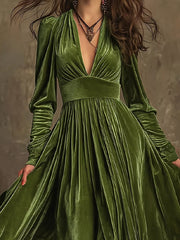 Dark green velvet maxi dress with plunging neckline, voluminous sleeves, and pleated skirt.