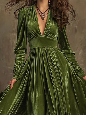 Dark green velvet maxi dress with plunging neckline, voluminous sleeves, and pleated skirt.