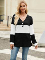 Ribbed Henley sweater with black and white colorblock, V-neck, and button detail.