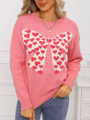 Pink acrylic sweater with a large heart bow graphic and round neck.