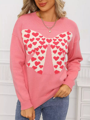 Pink acrylic sweater with a large heart bow graphic and round neck.