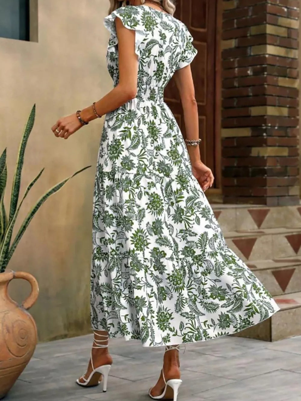 Botanical print midi dress with ruffle sleeves and smocked waist in white with green pattern.