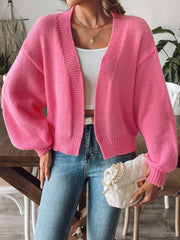 Balloon sleeve knit cardigan in strawberry pink with ribbed cuffs and open front.