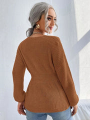 Caramel peplum knit sweater with a scallop neckline and long sleeves.