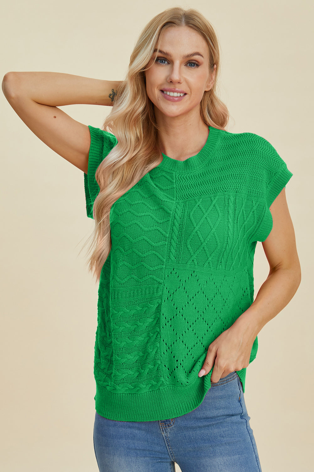 Green knit patchwork top with cable and diamond stitch details, short sleeves.