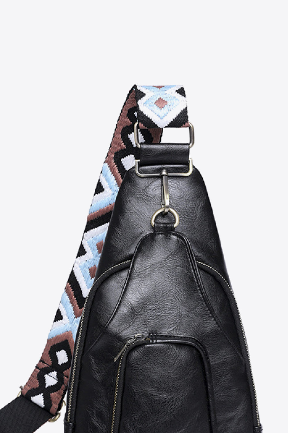 Black PU sling bag with a patterned strap and zippered front pocket.