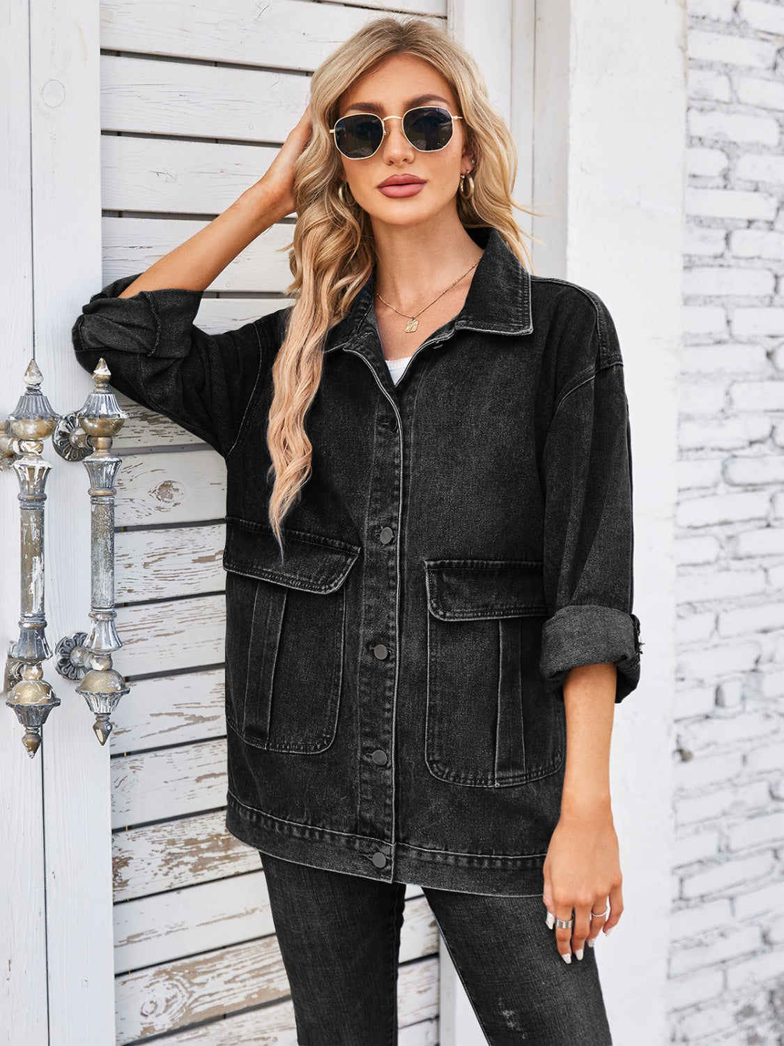 Black denim button-up jacket with two chest pockets and rolled sleeves.