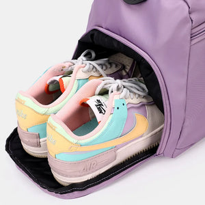 Mauve nylon duffle bag with mesh pocket holding colorful sneakers