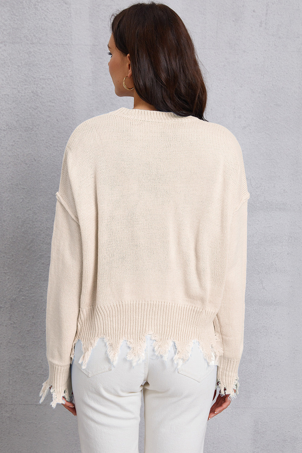 Cream knit sweater with distressed hem and cuffs, crew neck, long sleeves.