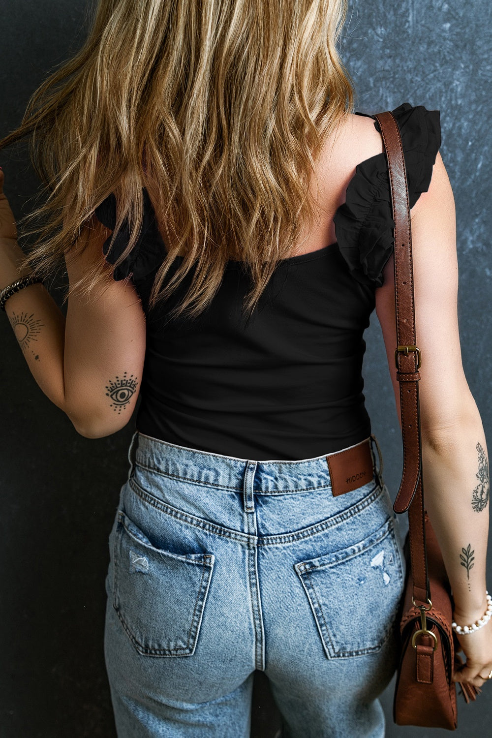 Black ribbed tank top with ruffled straps and a square neckline.