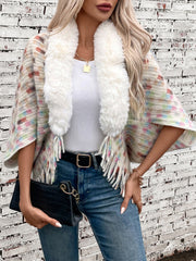 Textured plaid acrylic poncho with white faux fur collar and fringe, styled with jeans.