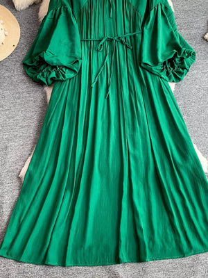 Green polyester maxi dress with balloon sleeves, drawstring waist, and ruffled cuffs.