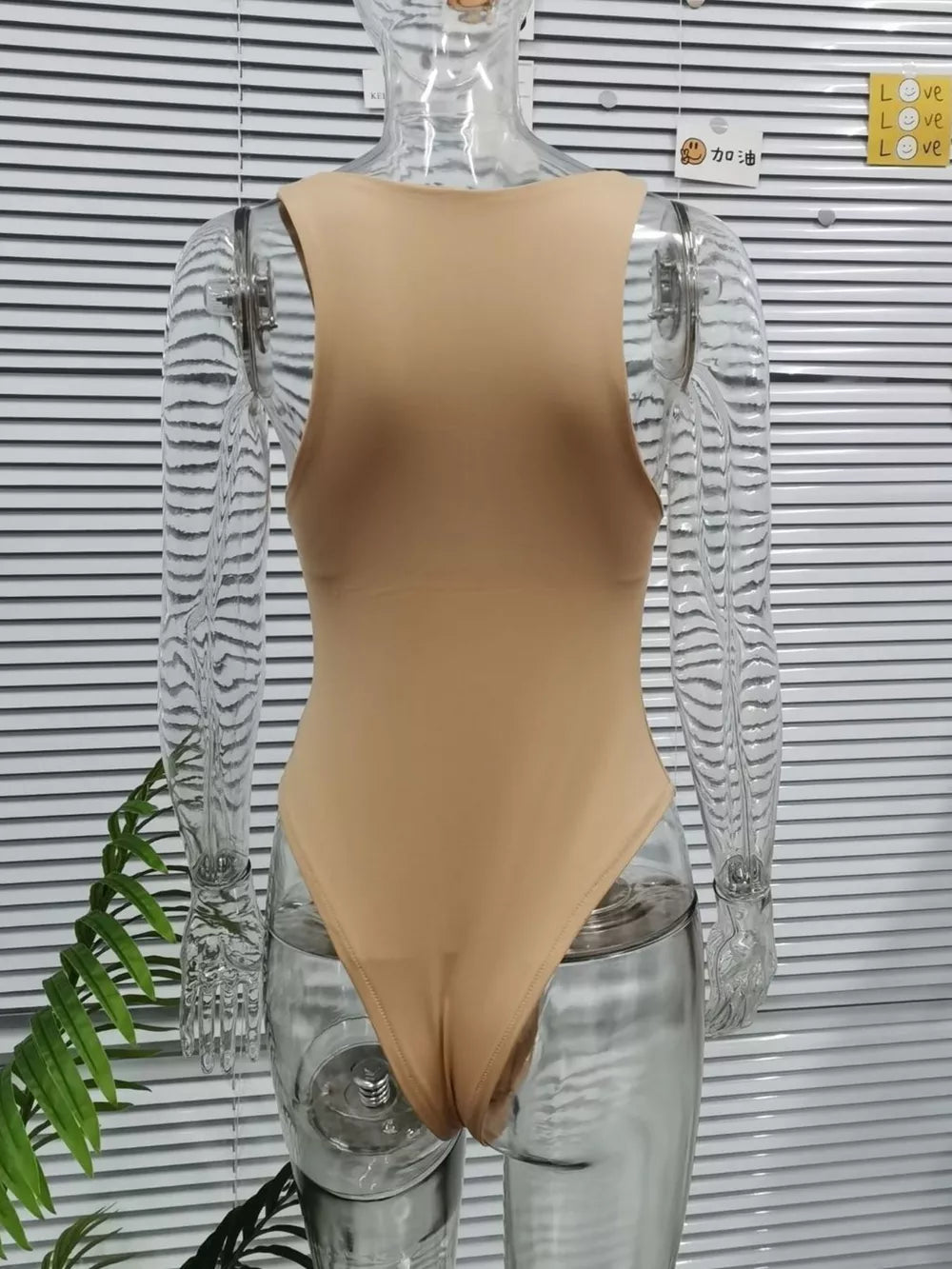 Skin color round neck sleeveless bodysuit with a comfortable, basic fit.