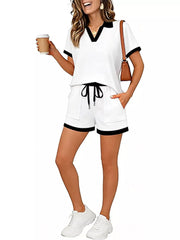 White polo collar two-piece set with black trim, drawstring shorts with pockets.