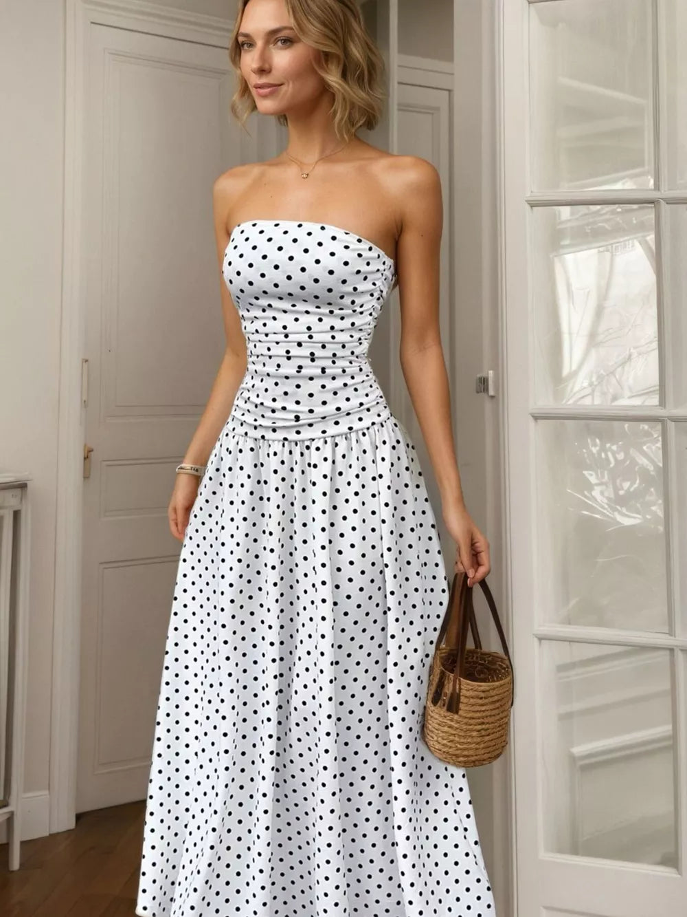 White polka dot strapless maxi dress with ruched bodice and full skirt.