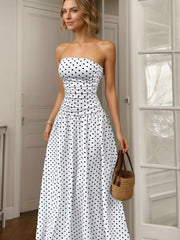 White polka dot strapless maxi dress with ruched bodice and full skirt.