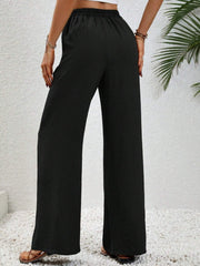 Black textured palazzo trousers with drawstring waist and wide legs.