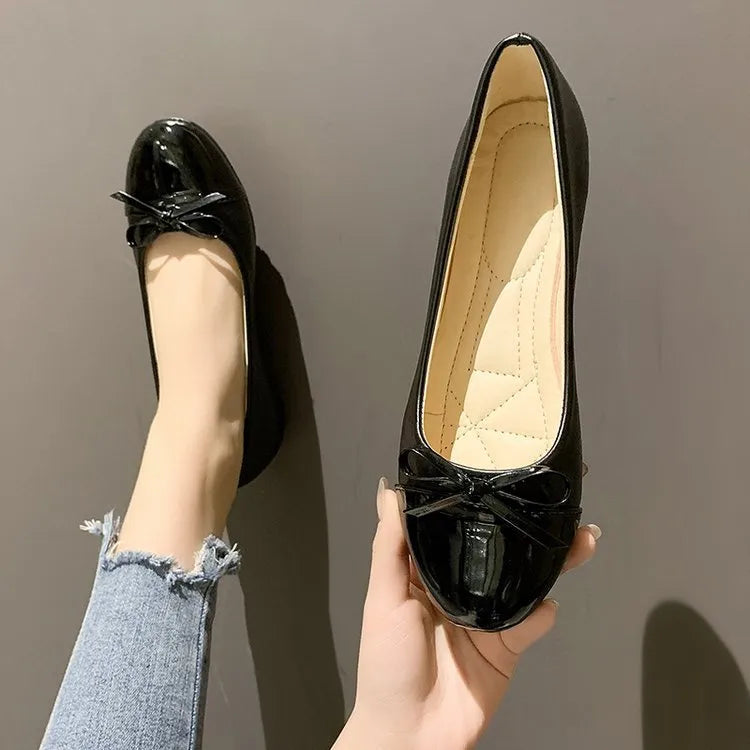 Patent bow ballet flats in black with a quilted insole.
